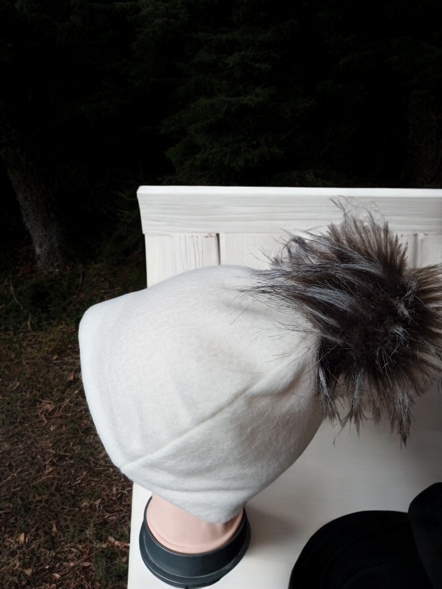 Cream women's fleece hat with brown/cream fur pompom.