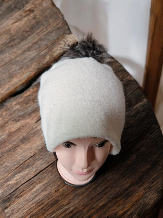 Cream women's fleece hat with brown/cream fur pompom.