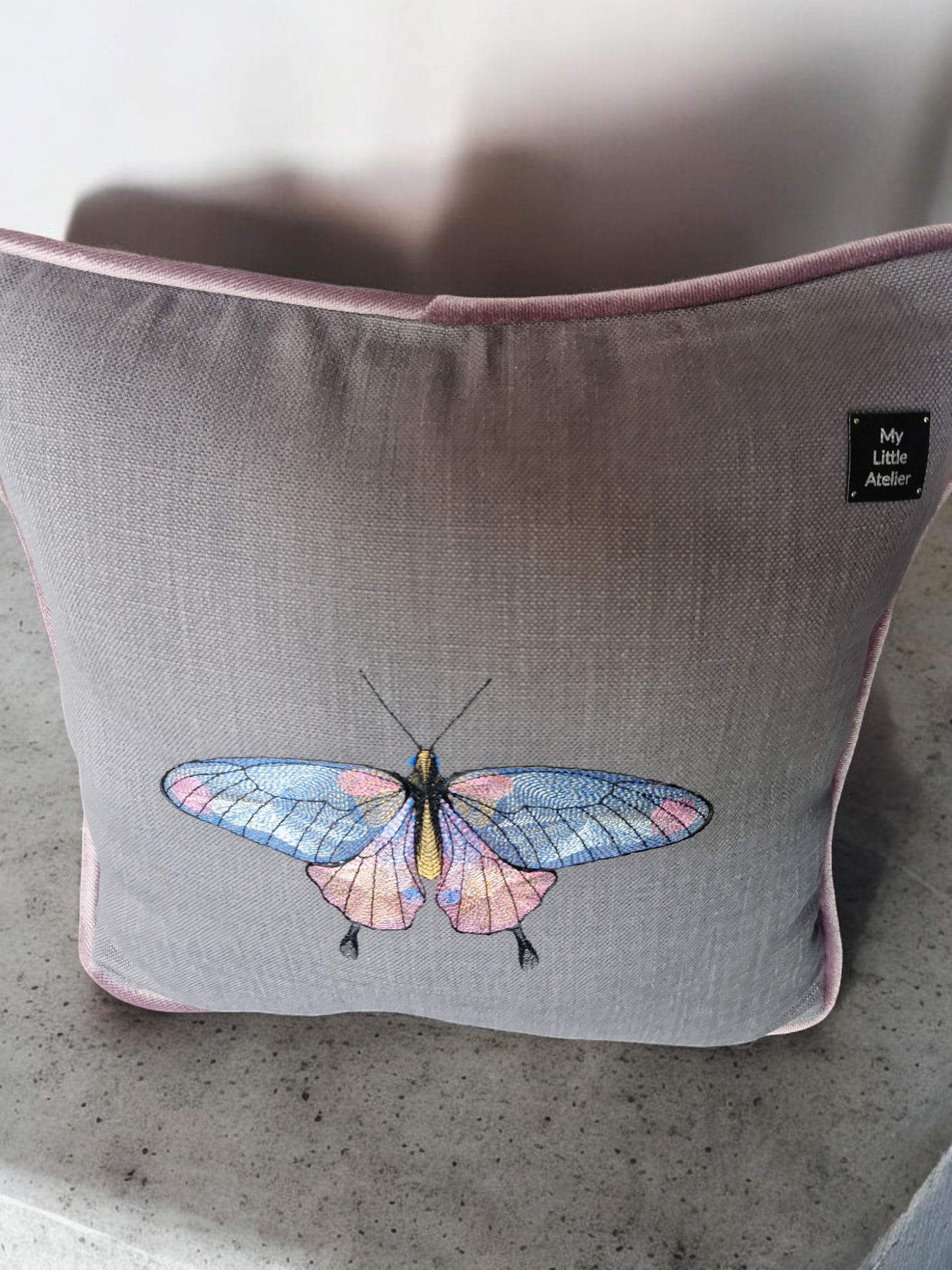 Embroidered cushion with "butterfly" motif