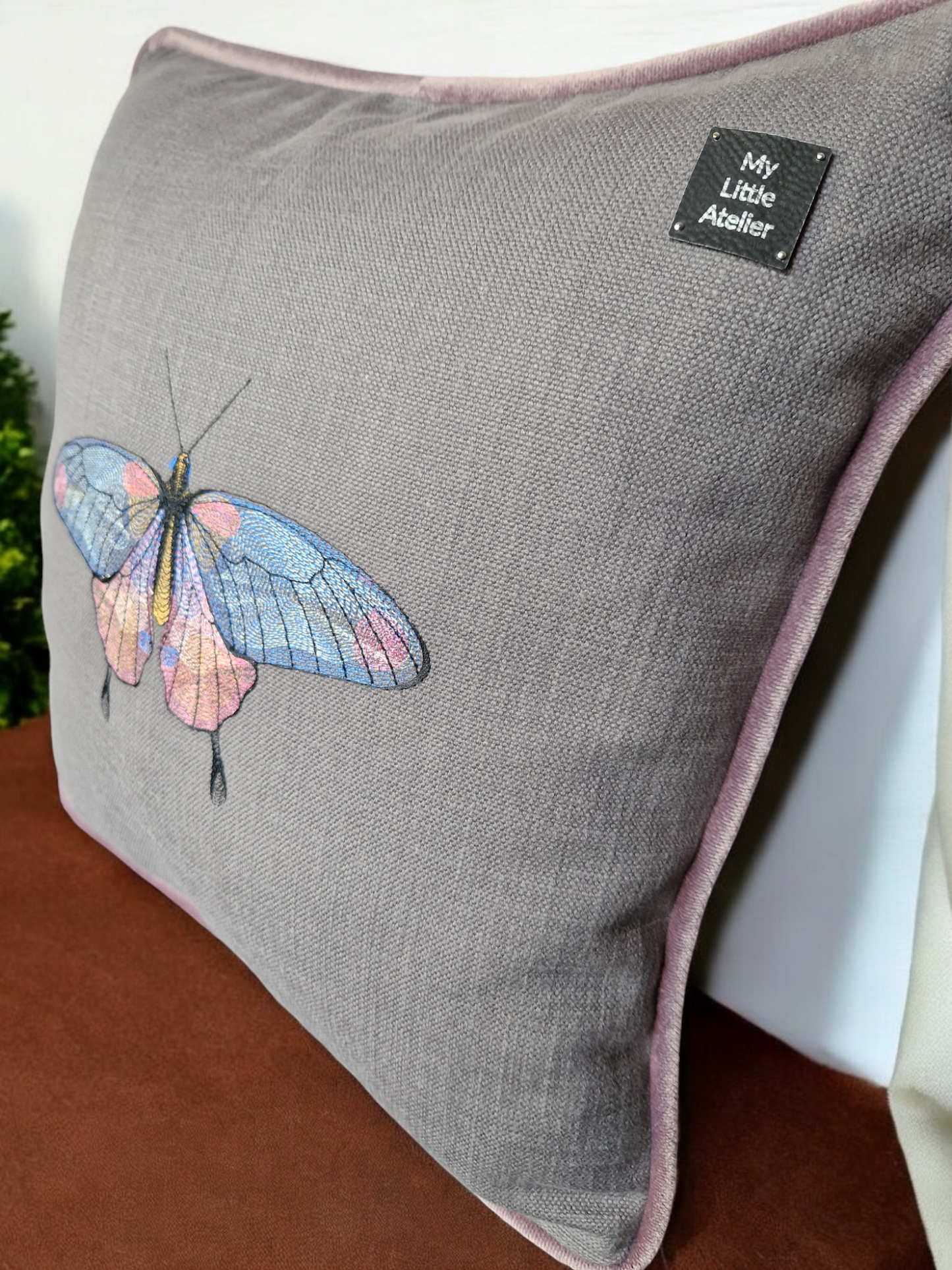 Embroidered cushion with "butterfly" motif