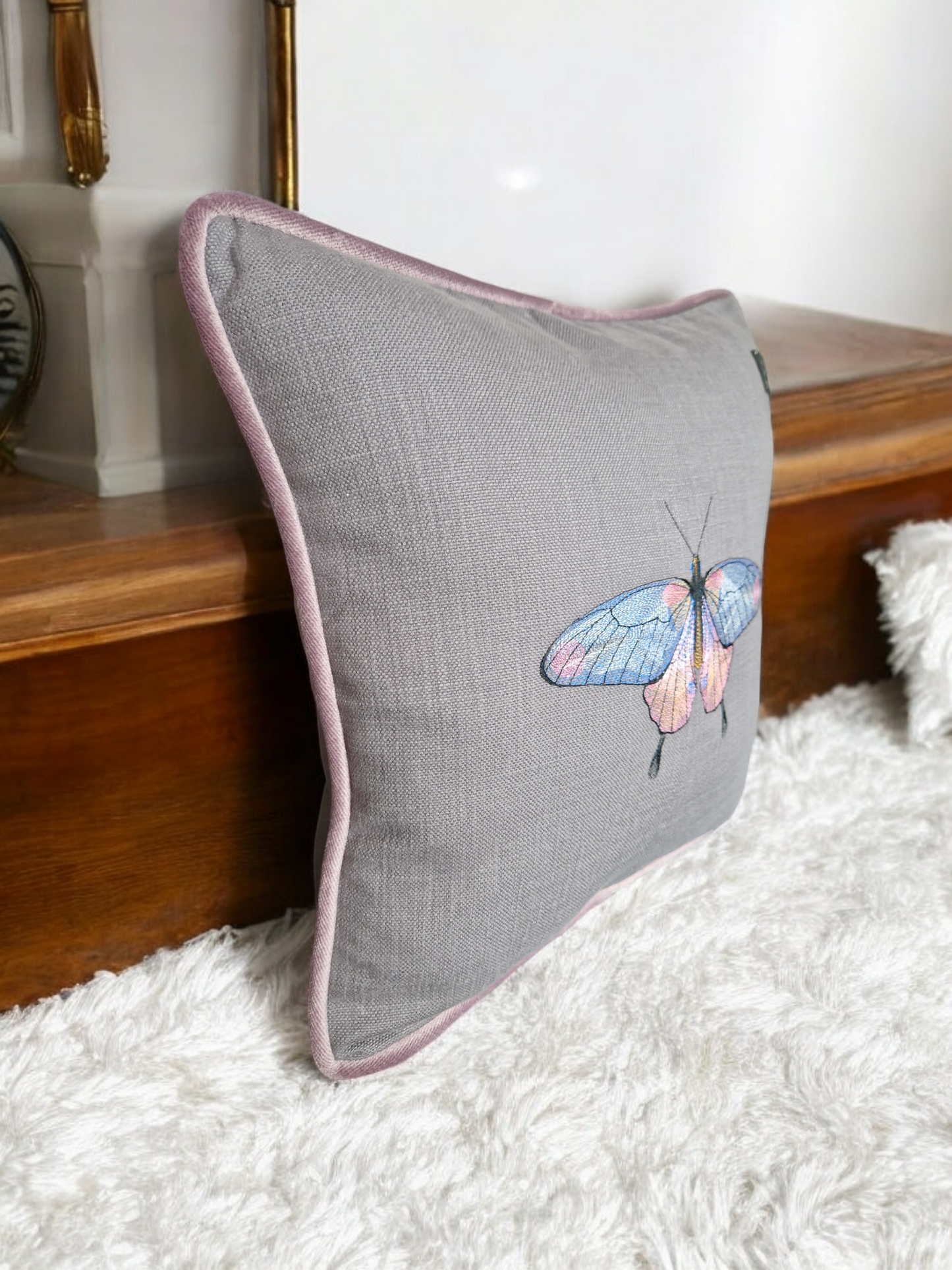 Embroidered cushion with "butterfly" motif