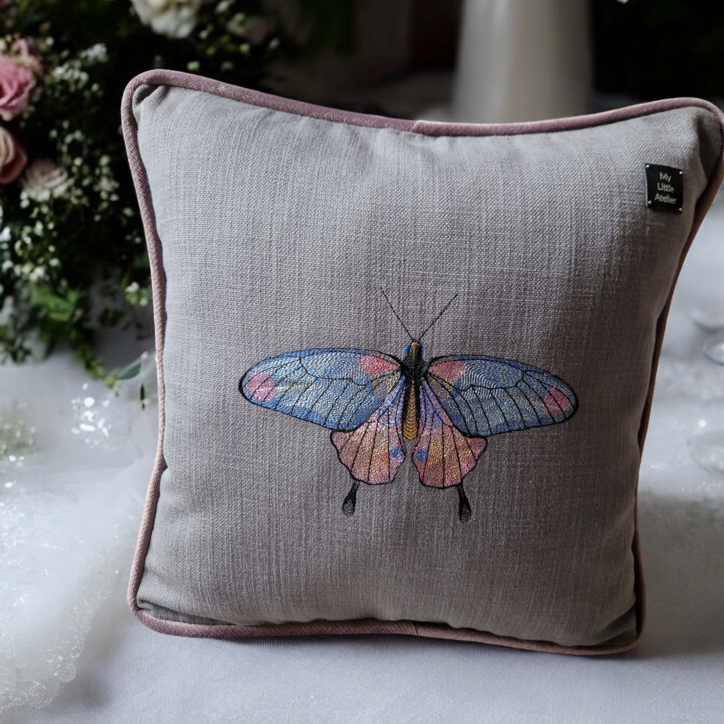 Embroidered cushion with "butterfly" motif