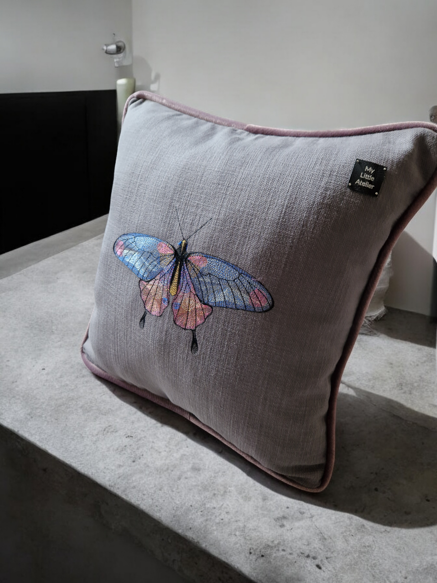 Embroidered cushion with "butterfly" motif