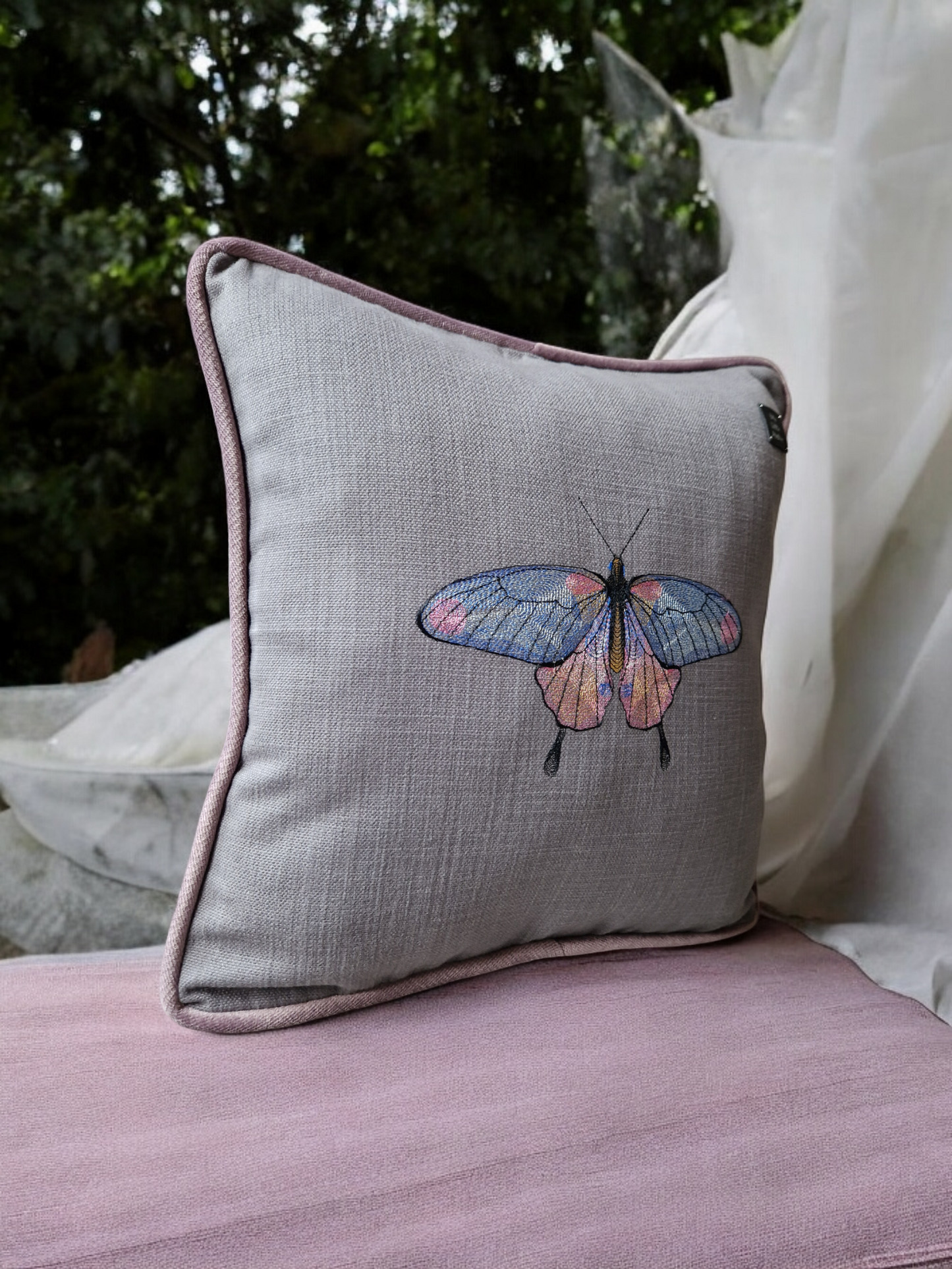 Embroidered cushion with "butterfly" motif