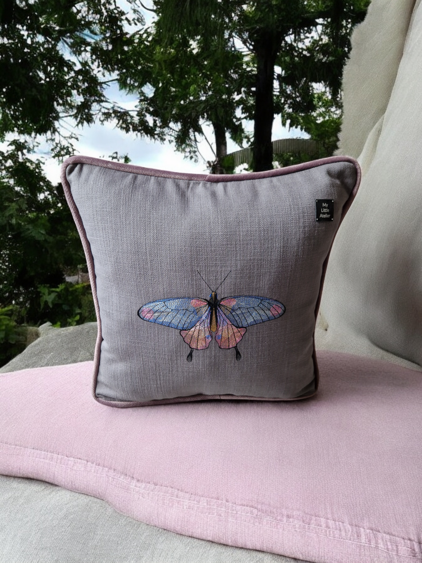 Embroidered cushion with "butterfly" motif