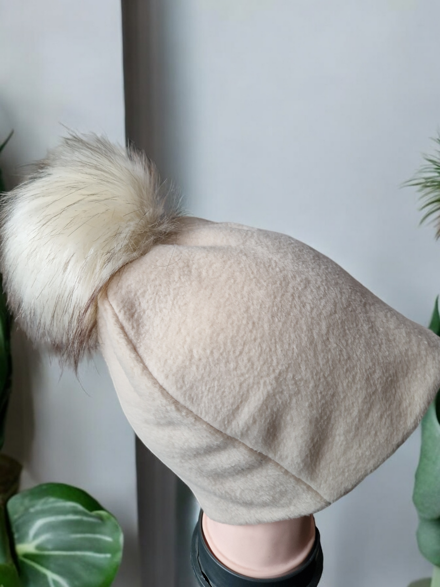 Cream beige women's fleece hat with cream fur pompom.