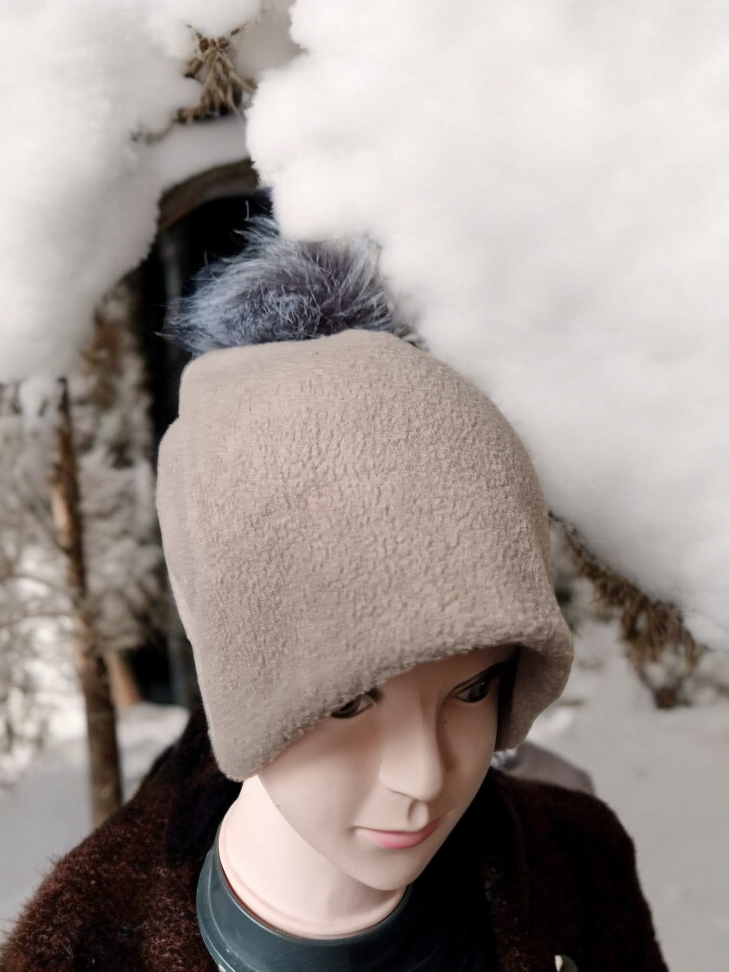 Beige women's fleece hat with grey fur pompom.