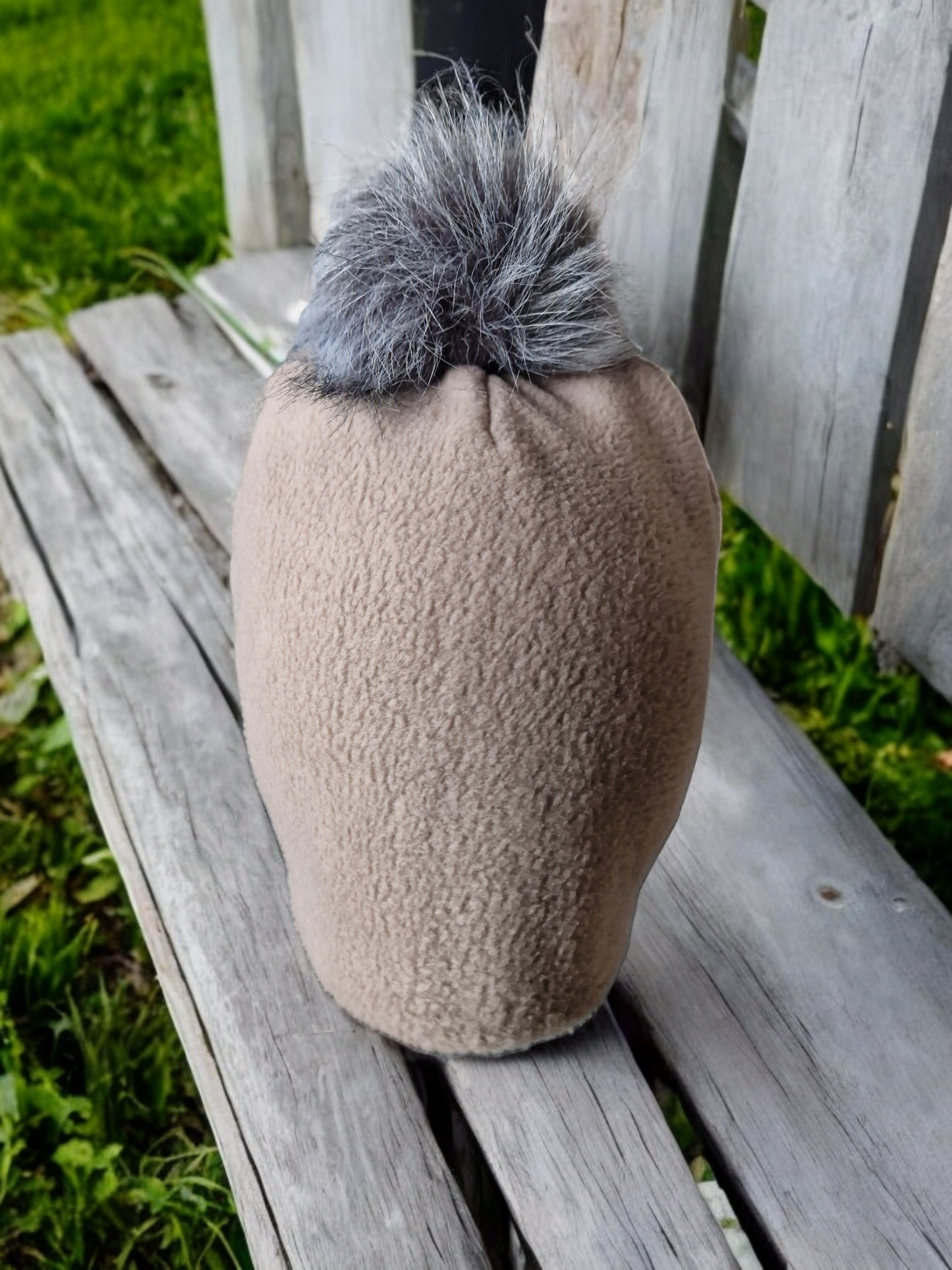 Beige women's fleece hat with grey fur pompom.