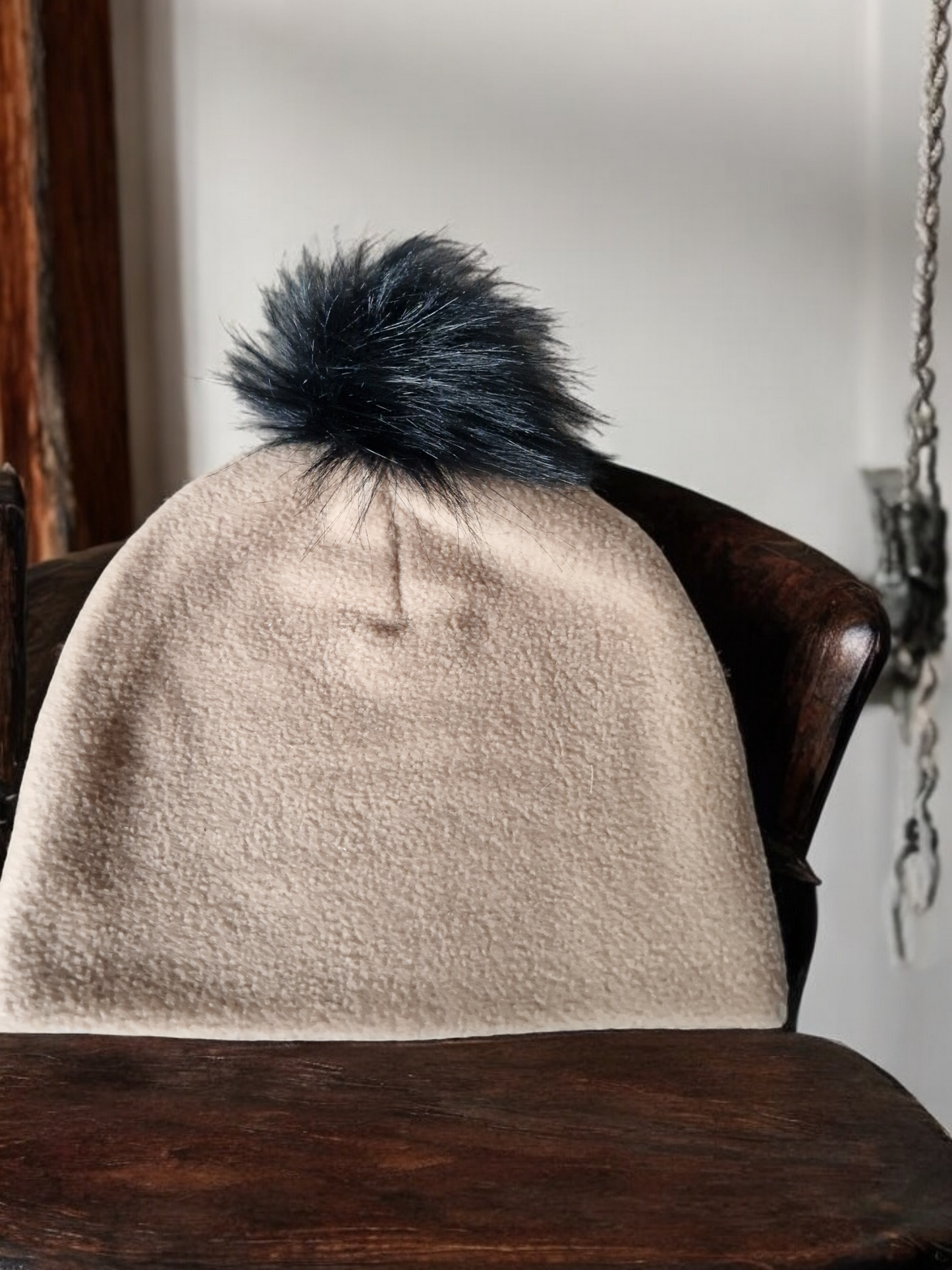 Carmel beige women's fleece hat with black fur pompom.