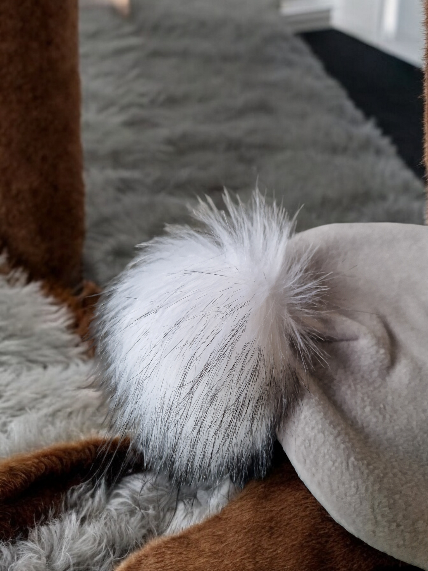 Light grey women's fleece hat with white fur pompom.