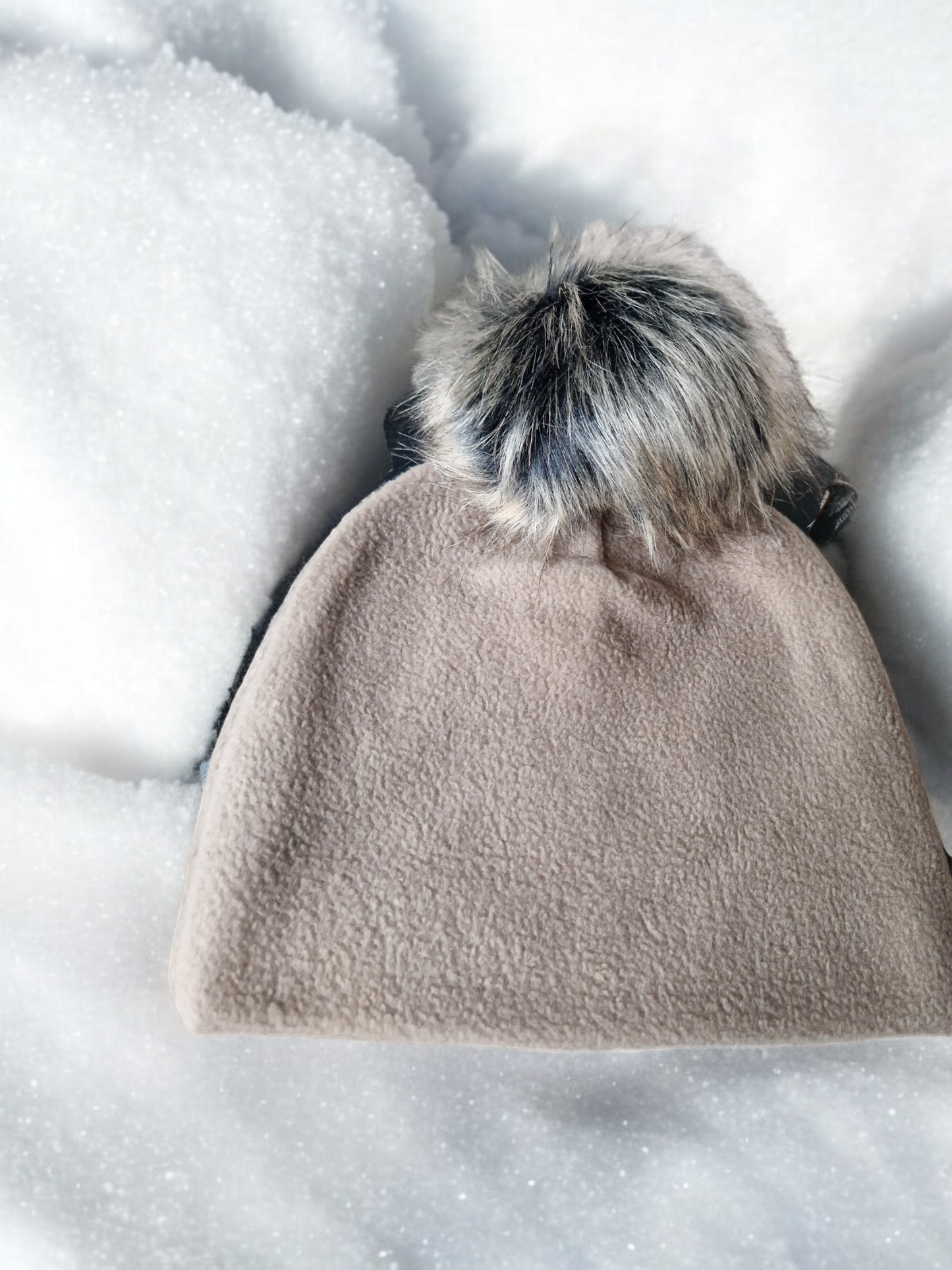 Beige women's fleece hat with beige fur pompom.