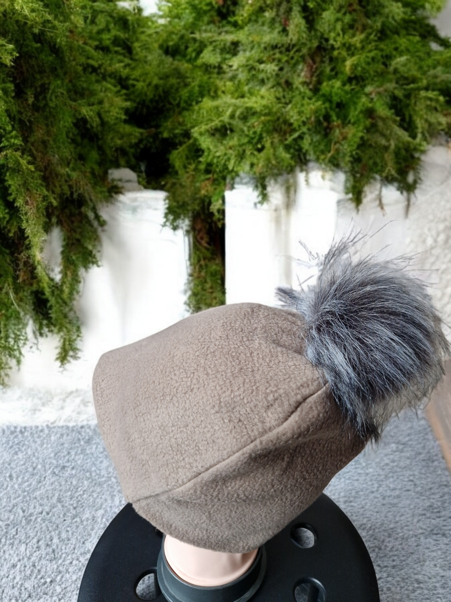 Beige women's fleece hat with grey fur pompom.